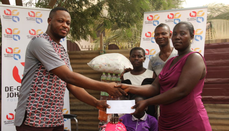 Papa Richie handing over the startup capital to Mrs Toku